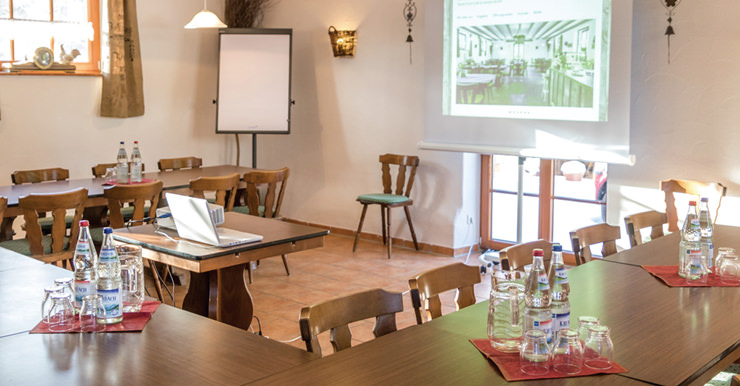 Seminarraum mit Tischen und Stühlen und Beamer